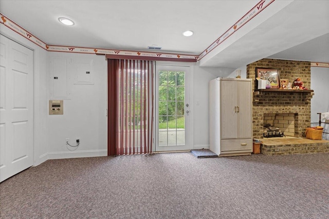 unfurnished living room with electric panel, carpet floors, and a brick fireplace