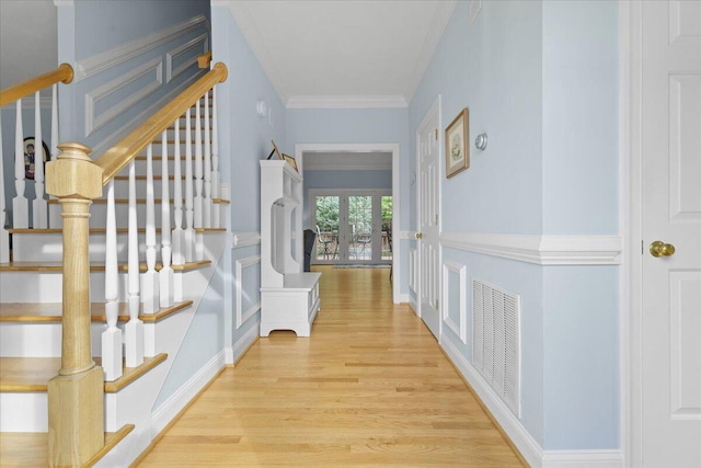 entrance foyer featuring ornamental molding and light wood-type flooring