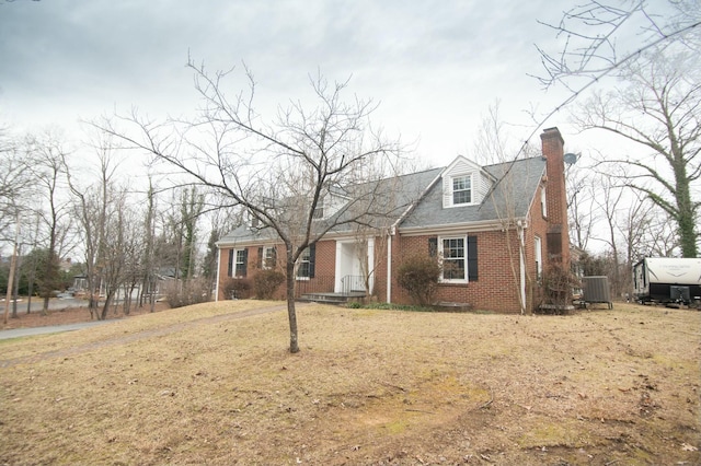 new england style home featuring central AC unit and a front yard