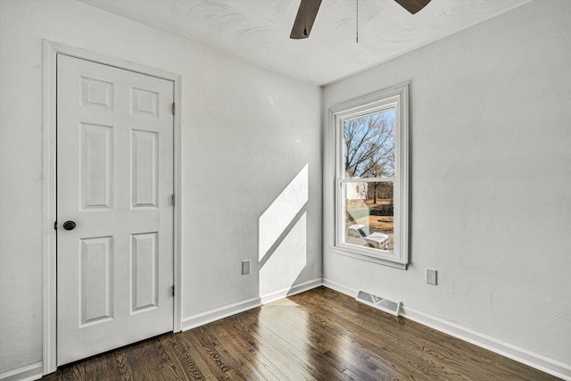 spare room with dark hardwood / wood-style flooring and ceiling fan