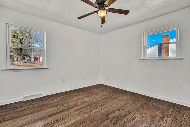 unfurnished room featuring ceiling fan, a wealth of natural light, and dark hardwood / wood-style flooring