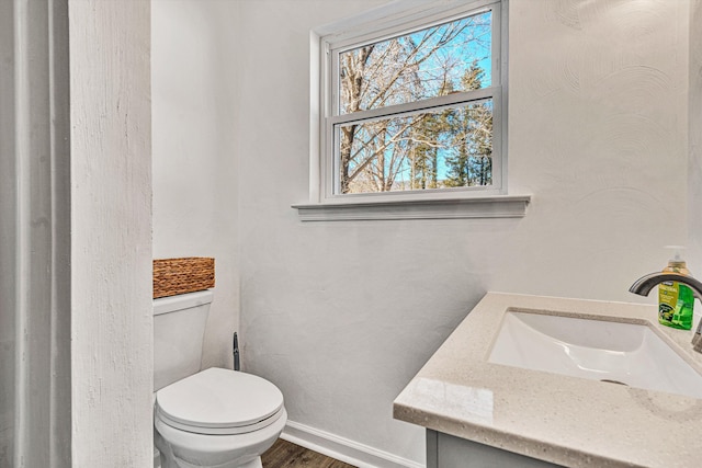 bathroom with hardwood / wood-style flooring, vanity, and toilet