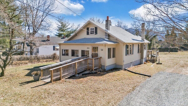 rear view of property with a yard and a deck