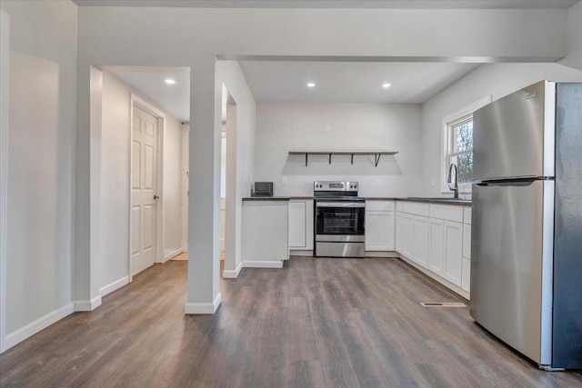 kitchen featuring stainless steel appliances, dark hardwood / wood-style flooring, sink, and white cabinets