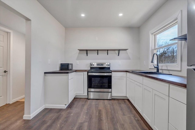 kitchen featuring dark hardwood / wood-style flooring, sink, stainless steel electric range, and white cabinets