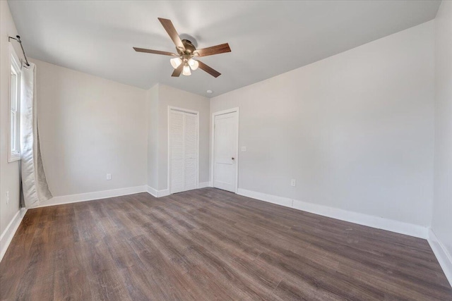 spare room with dark hardwood / wood-style floors and ceiling fan