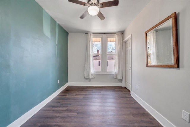 unfurnished room featuring dark wood-type flooring and ceiling fan