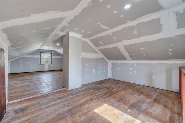 additional living space with wood-type flooring and lofted ceiling