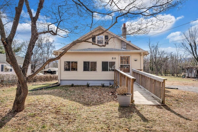 bungalow featuring a wooden deck and a front yard