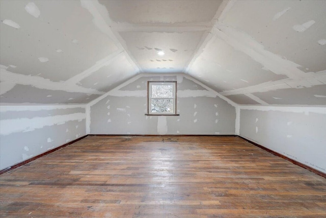 additional living space featuring lofted ceiling and dark wood-type flooring