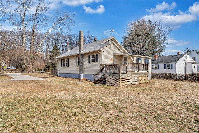 view of front of property featuring a wooden deck and a front lawn