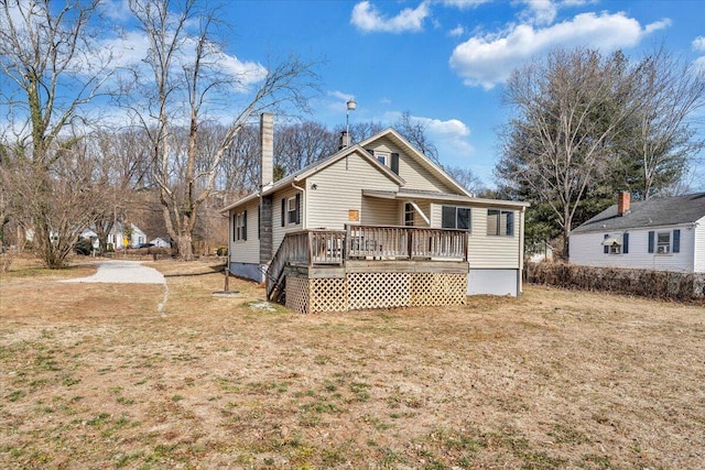 back of house with a lawn and a deck