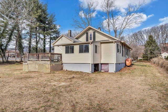 view of home's exterior with a wooden deck and a yard