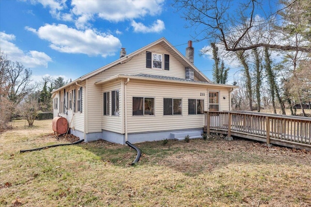 back of property with a yard and a deck