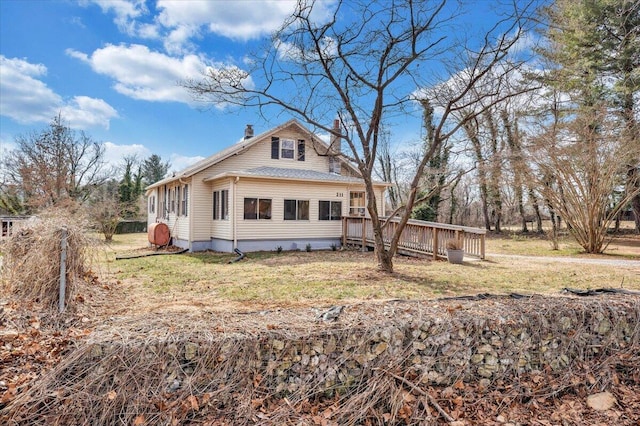 rear view of property featuring a lawn and a deck