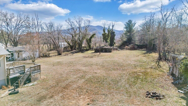 view of yard with a deck with mountain view