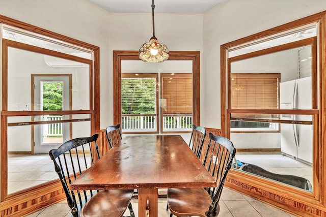 dining area with a wall mounted AC and light tile patterned flooring