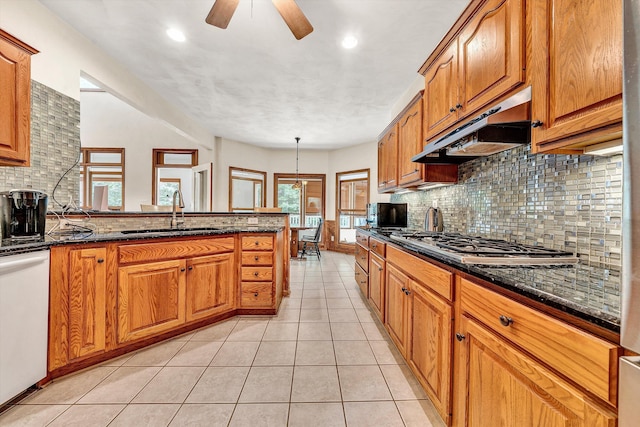 kitchen with sink, decorative light fixtures, dishwasher, stainless steel gas stovetop, and dark stone counters