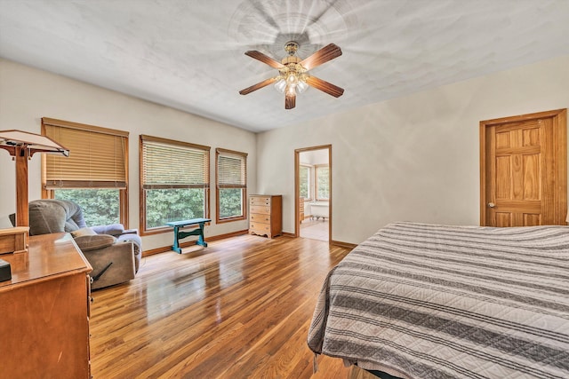 bedroom with ceiling fan, light wood-type flooring, and ensuite bath