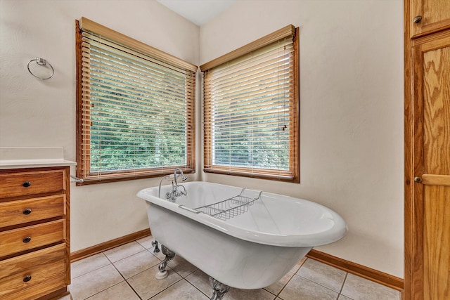 bathroom featuring tile patterned flooring, a bathing tub, and vanity