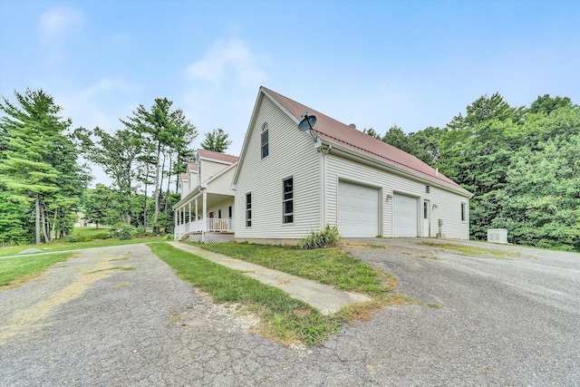 view of side of home featuring a garage and a porch