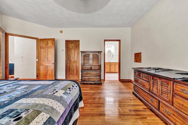 bedroom featuring ensuite bath and light wood-type flooring