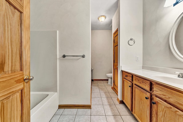 bathroom featuring vanity, a bathing tub, tile patterned floors, and toilet