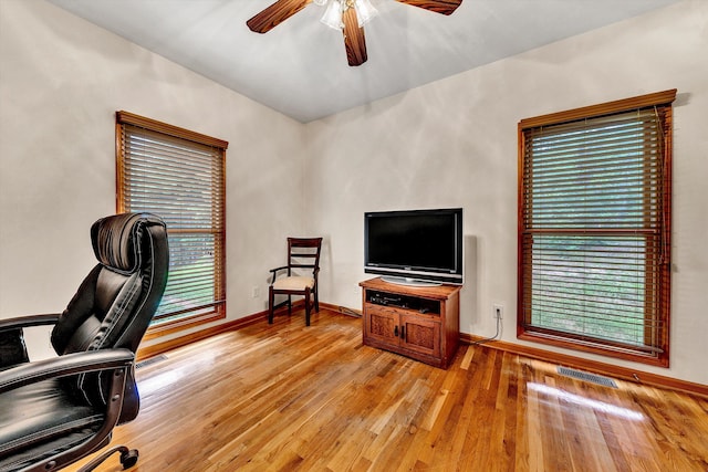 home office with ceiling fan and light hardwood / wood-style floors