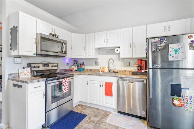 kitchen with sink, white cabinetry, light stone counters, tasteful backsplash, and appliances with stainless steel finishes