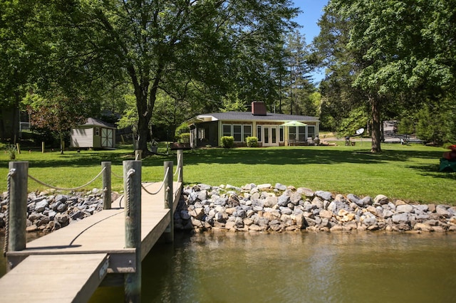 dock area featuring a lawn and a water view