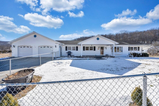 view of front of property featuring a garage, fence private yard, and driveway