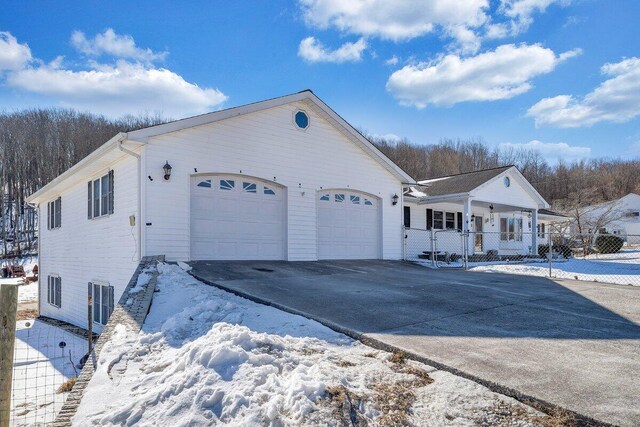 snow covered rear of property with a garage