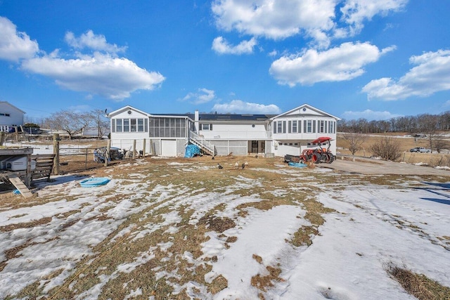 rear view of house with a sunroom and stairs