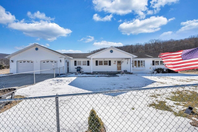 view of front of property featuring driveway, an attached garage, and fence