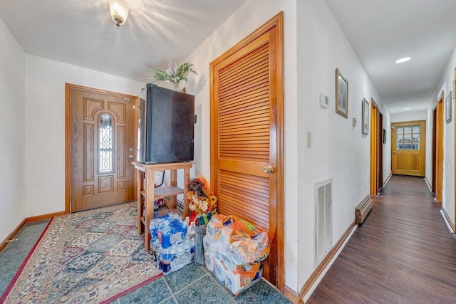 entryway with wood finished floors, visible vents, baseboards, baseboard heating, and plenty of natural light