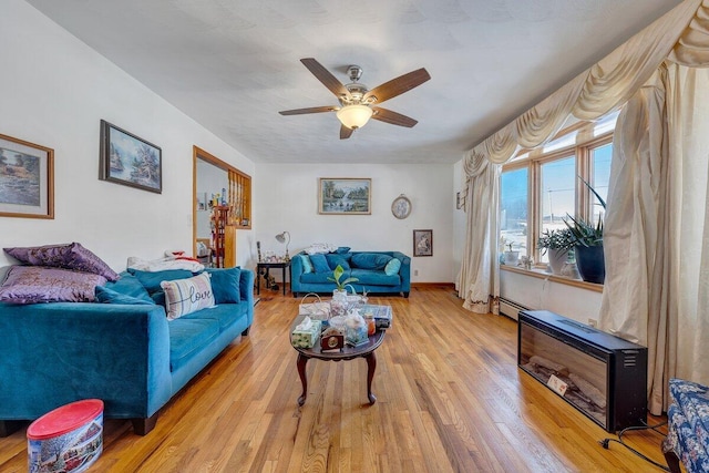 living room featuring light wood-type flooring, ceiling fan, and baseboards