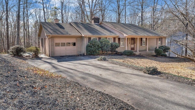 ranch-style home with a garage and covered porch