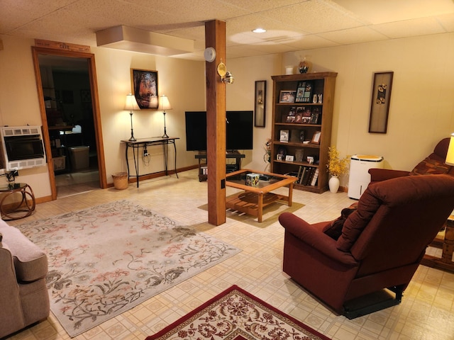 living room with a paneled ceiling and heating unit