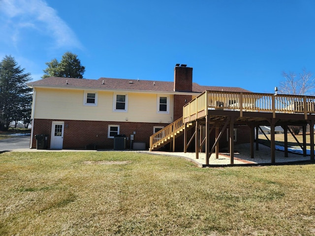 rear view of property with a wooden deck, a yard, and central air condition unit