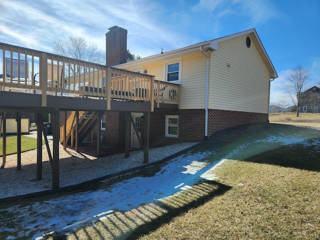 rear view of house with a wooden deck and a lawn