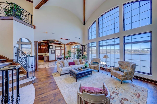 living room featuring lofted ceiling, wood-type flooring, and ornate columns