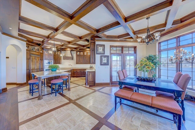 dining area featuring beamed ceiling, coffered ceiling, crown molding, and a notable chandelier