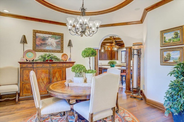 dining space featuring ornamental molding, a chandelier, and light hardwood / wood-style floors