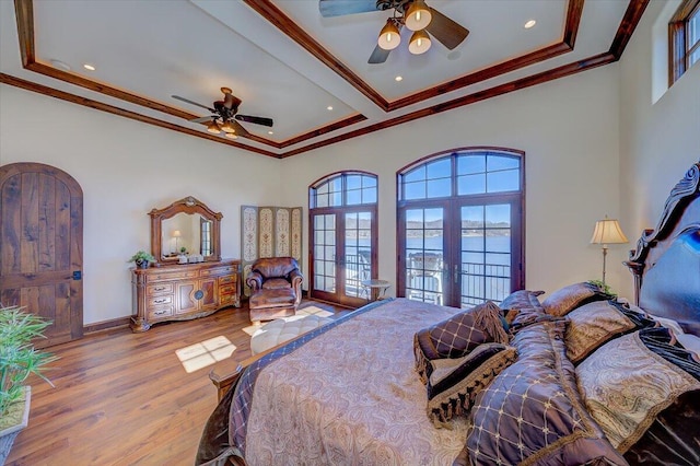 bedroom featuring crown molding, ceiling fan, light wood-type flooring, and french doors