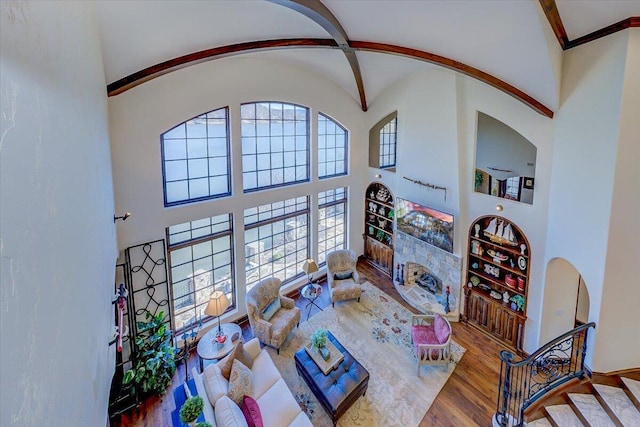 living room featuring crown molding, hardwood / wood-style flooring, and a high ceiling