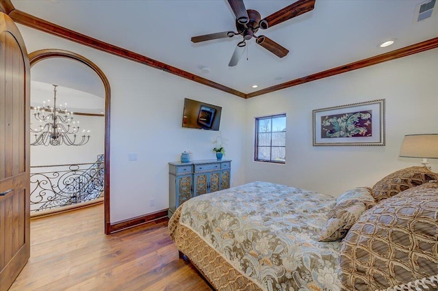 bedroom with hardwood / wood-style floors, crown molding, and ceiling fan with notable chandelier