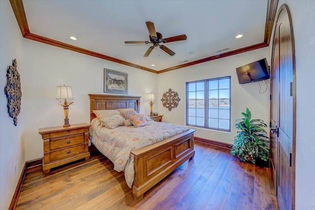 bedroom featuring hardwood / wood-style flooring, crown molding, and ceiling fan