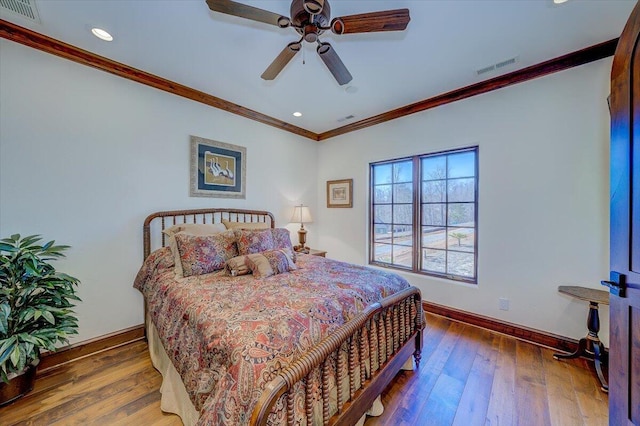 bedroom featuring ornamental molding, dark wood-type flooring, and ceiling fan