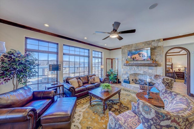 living room featuring crown molding, a fireplace, and ceiling fan