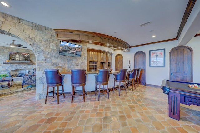 bar featuring ceiling fan and ornamental molding